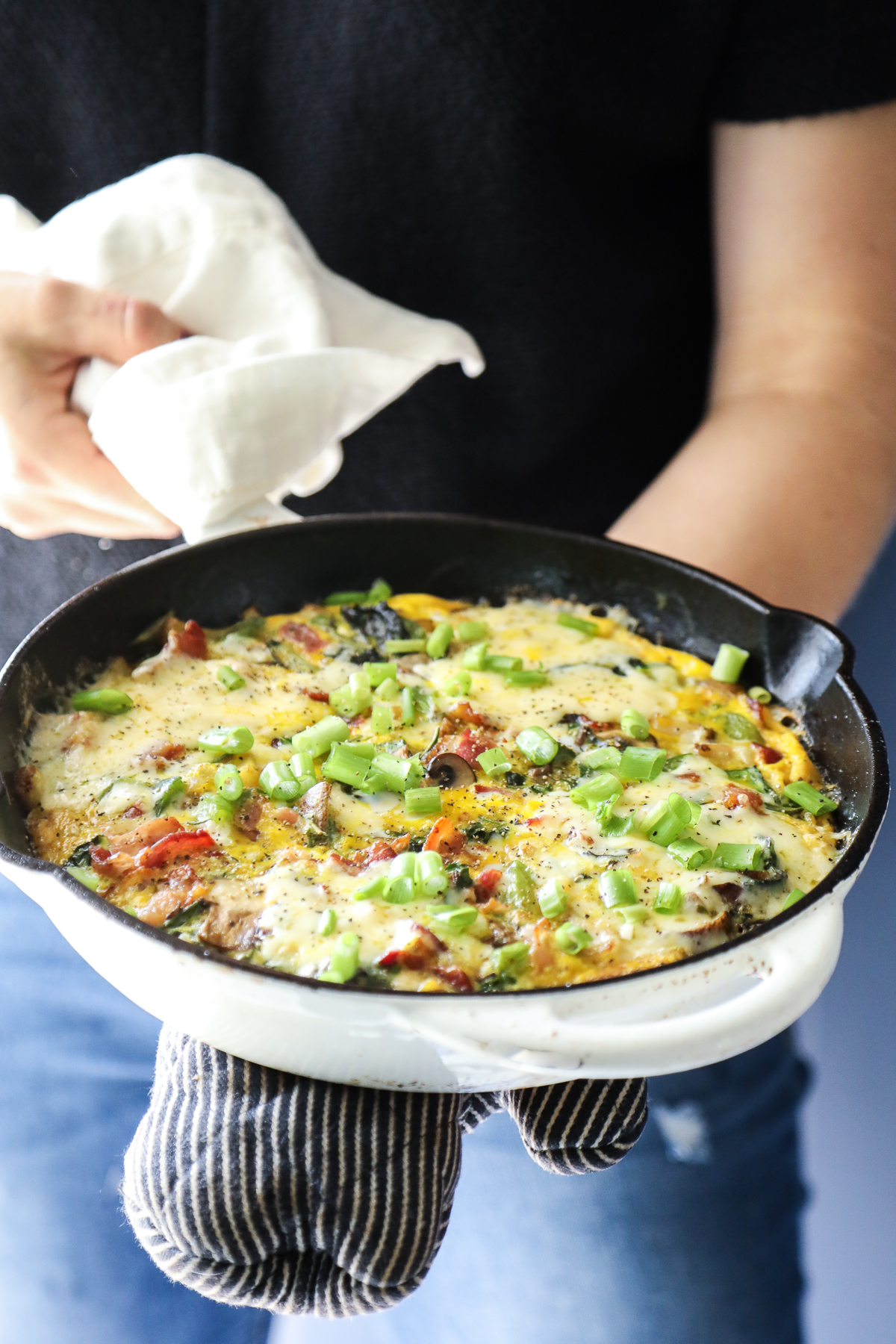 Frittata made with bacon, potatoes, peppers in a cast iron skillet.