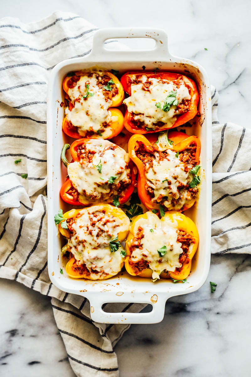 Melted cheese over the stuffed bell peppers in a baking dish.