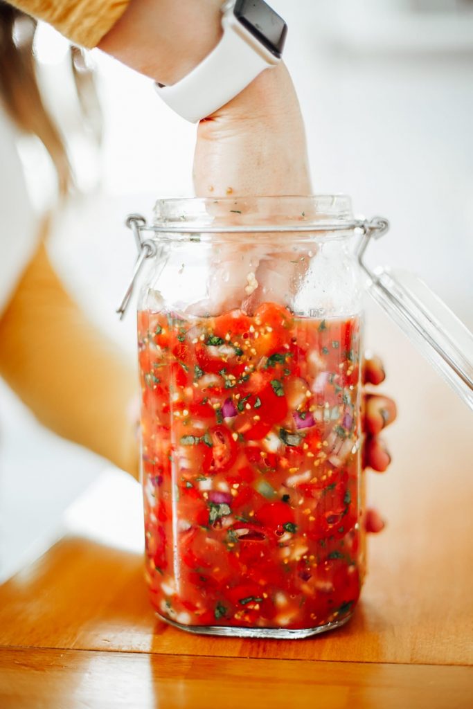adding salsa to the jar to ferment