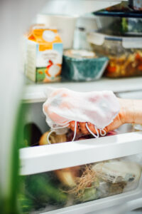 Placing bell peppers inside a reusable cloth bag in the crisper drawer in the fridge.