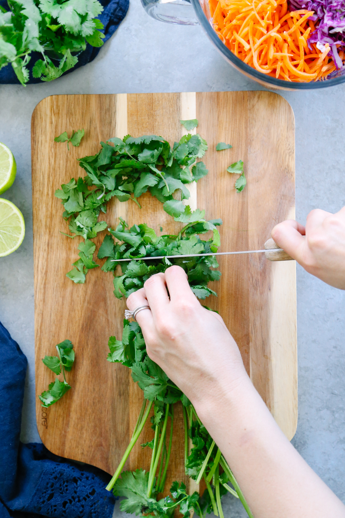 Cutting cilantro on a cutting board with a knife.