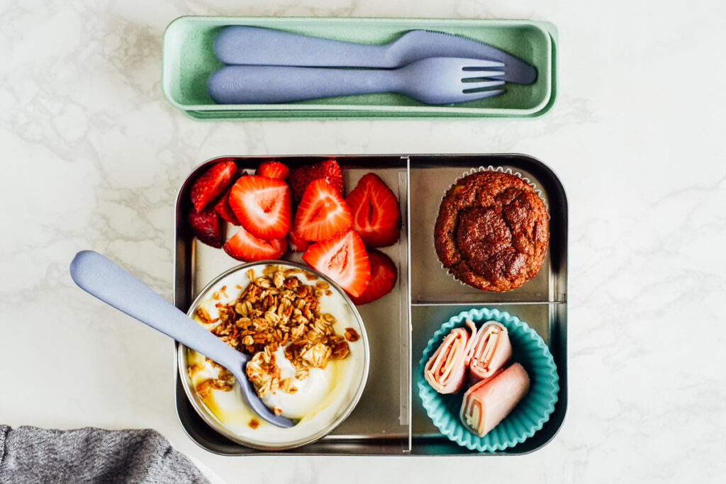 Build your own parfait lunch: yogurt, honey, granola, strawberries, with a muffin on the side and rolled up ham.